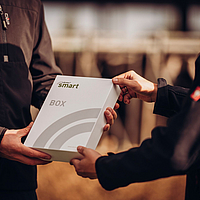 two people holding a Lubratec SmartBox package