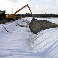 Excavator spreads soil over Basetrac® Duo geocomposite