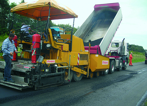 A new layer of asphalt is laid by an asphalt paver