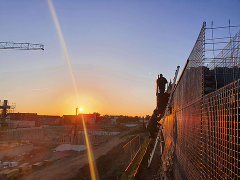 Bauarbeiter arbeiten an einer Lärmschutzwand 