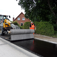 Workers laying SamiGrid® composite with a laying traverse