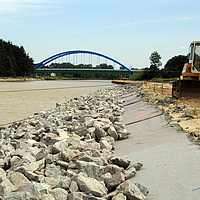 Geotextile nonwoven fabric and stones on river edge for bank protection