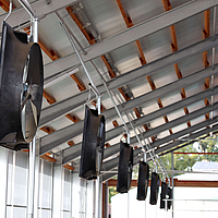 Side view of several axial fans in a cow barn