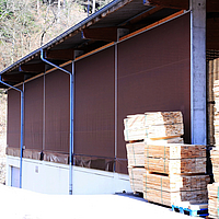 Brown windbreak nets as cladding for a timber warehouse