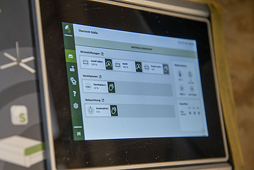 Detailansicht auf ein im Milchkuhstall installiertes Lubratec SmartPad, welches auf dem integrierten Display unterschiedliche Einstellungen aufzeigt