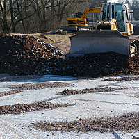 Bulldozer at work, spreading rubble on a construction site