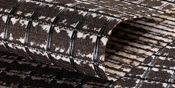 SamiGrid® asphalt reinforcement - close-up view of the material SamiGrid® composite of PVA grid and bitumen-saturated nonwoven in close-up view